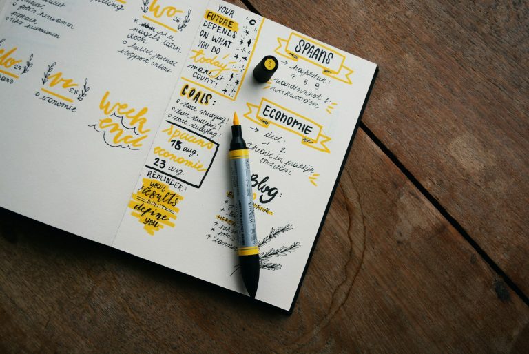 Agenda et stylo posés sur un bureau, illustrant la planification des absences liées au congé supplémentaire de naissance
